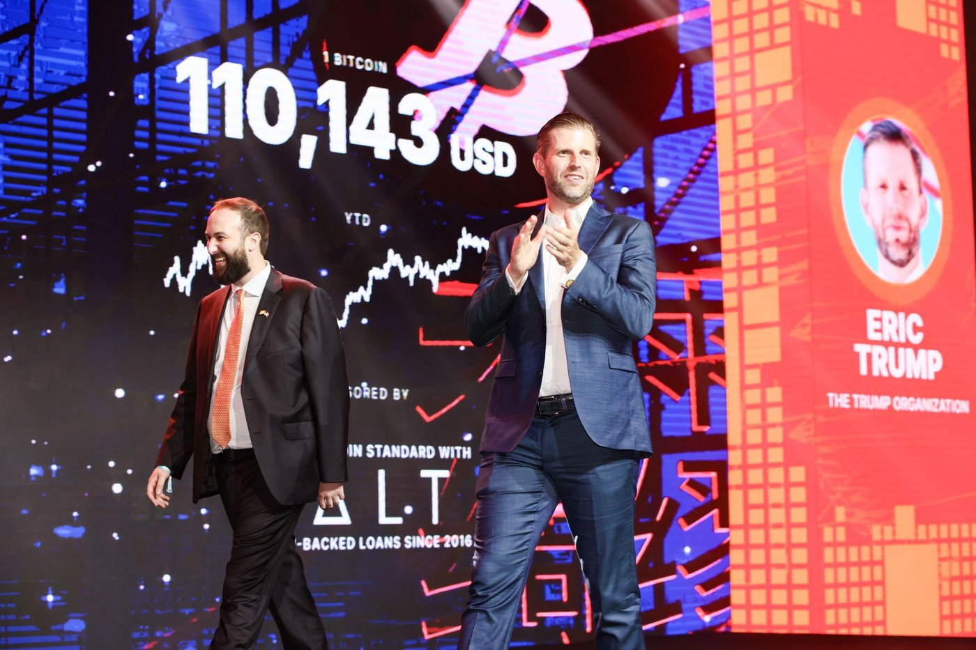 Eric Trump on stage with the live Bitcoin price ticker behind him.