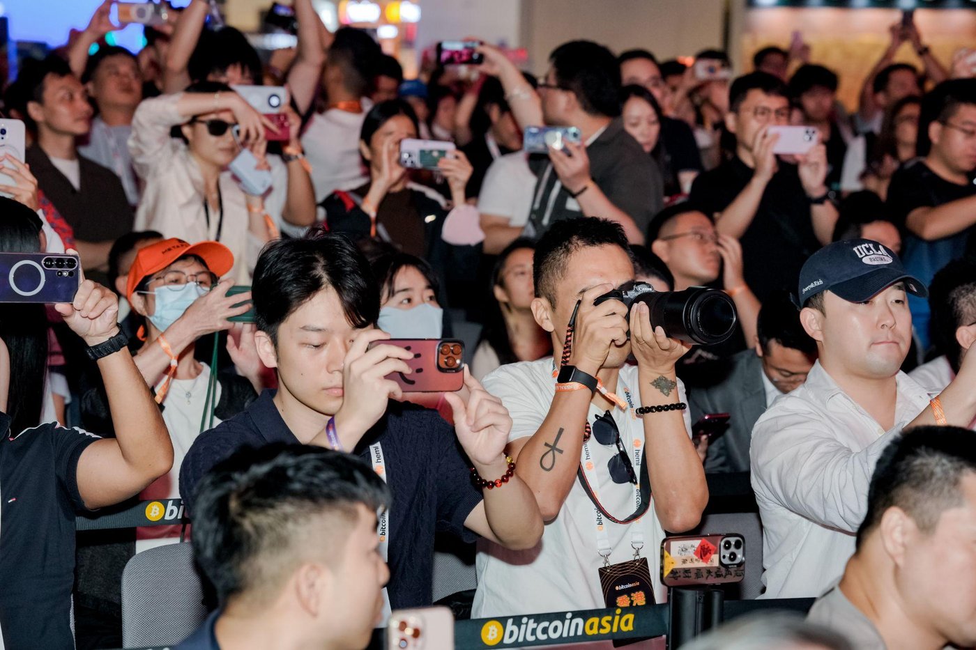Press and attendees with phones raised at a keynote moment.